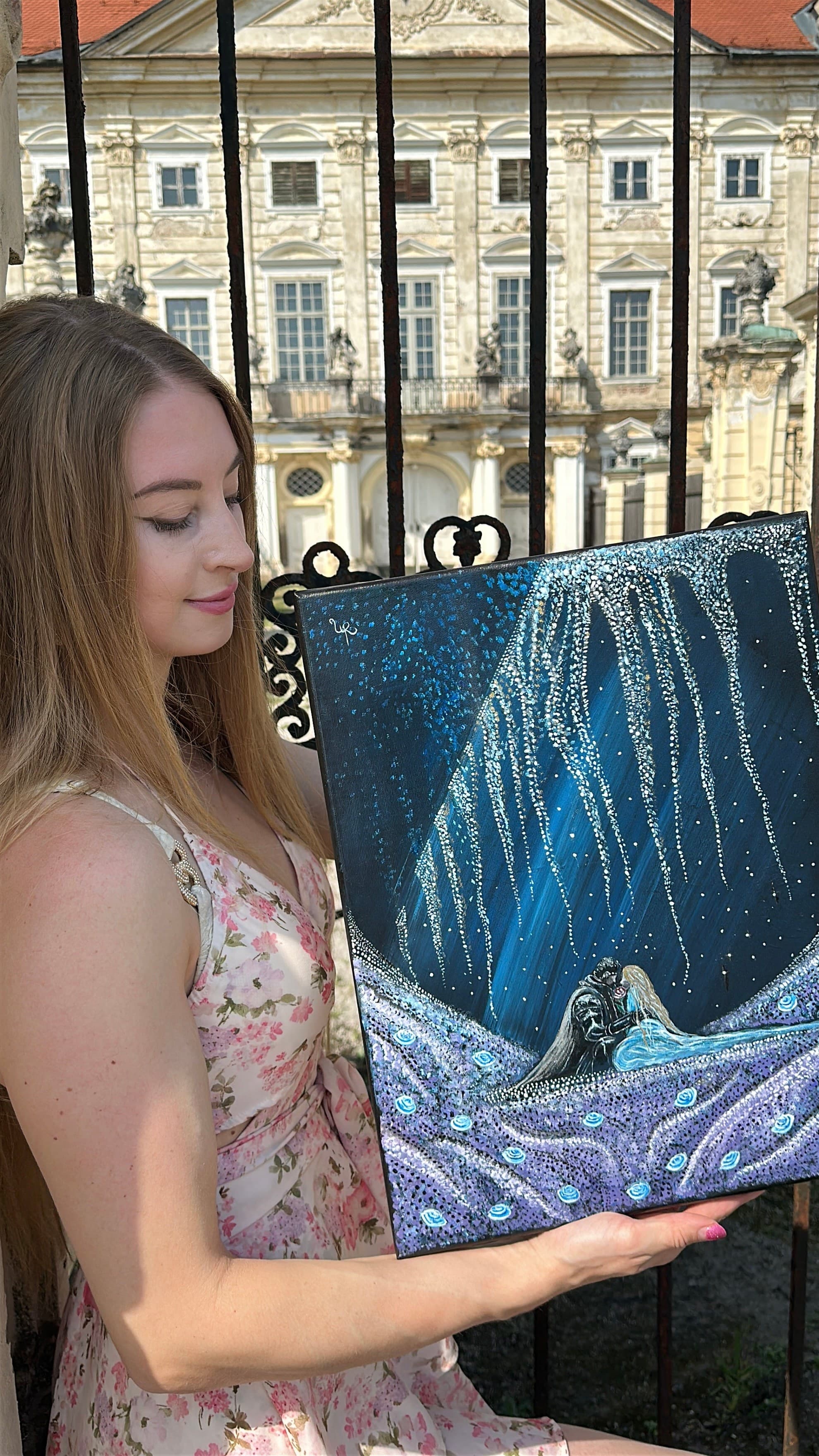 Urška holding the finished 'Blossoming Love' canvas outdoors