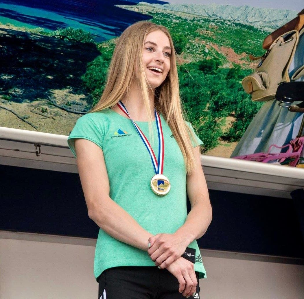 Urška smiling with a gold medal around her neck