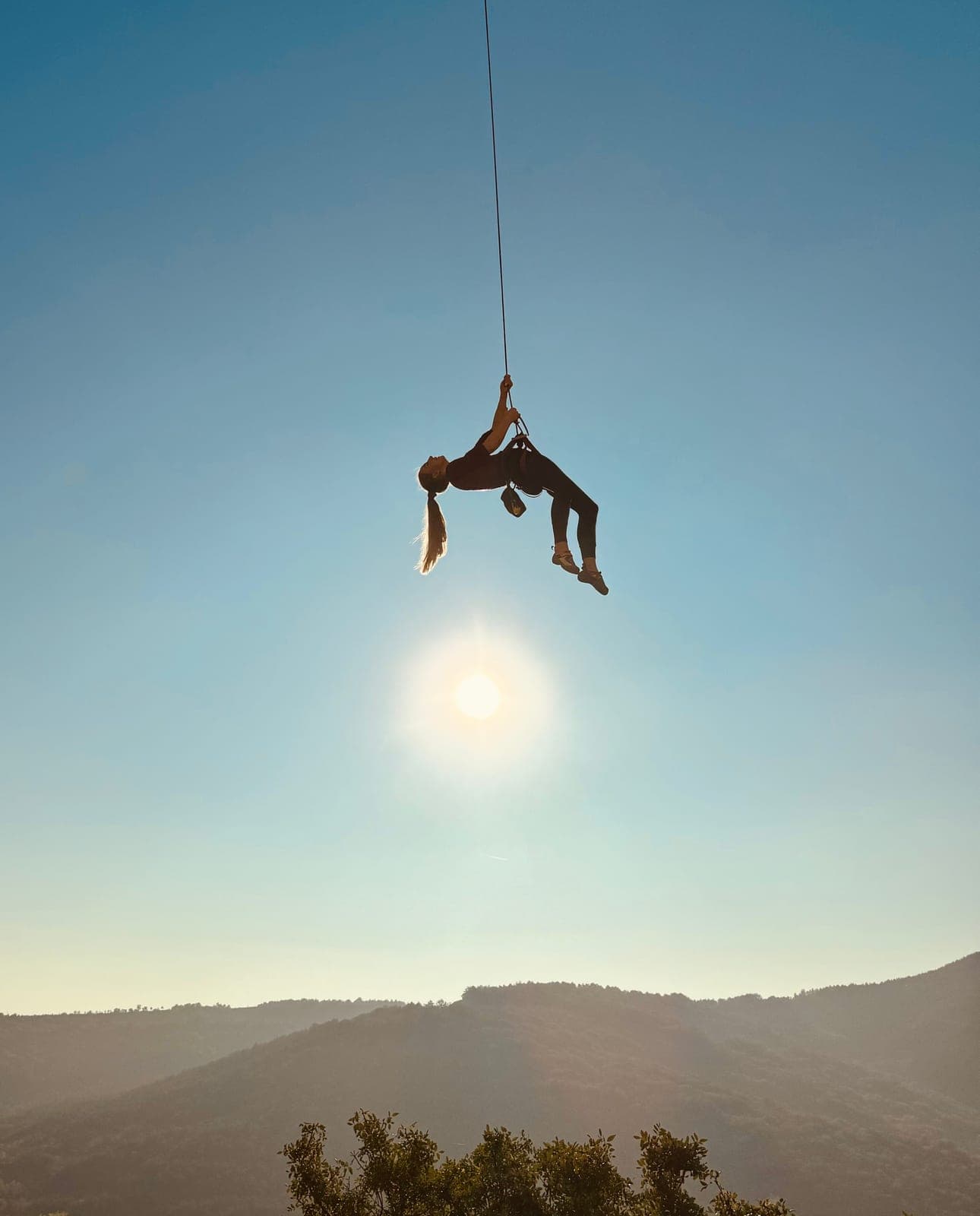 Urška hanging on a rope against the sun