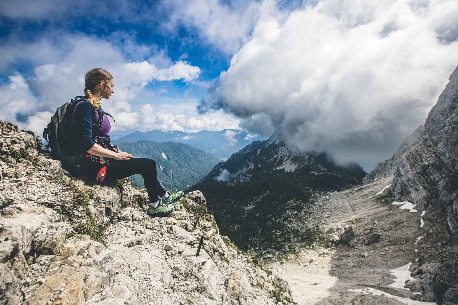 Urška resting on a mountain ridge above the clouds