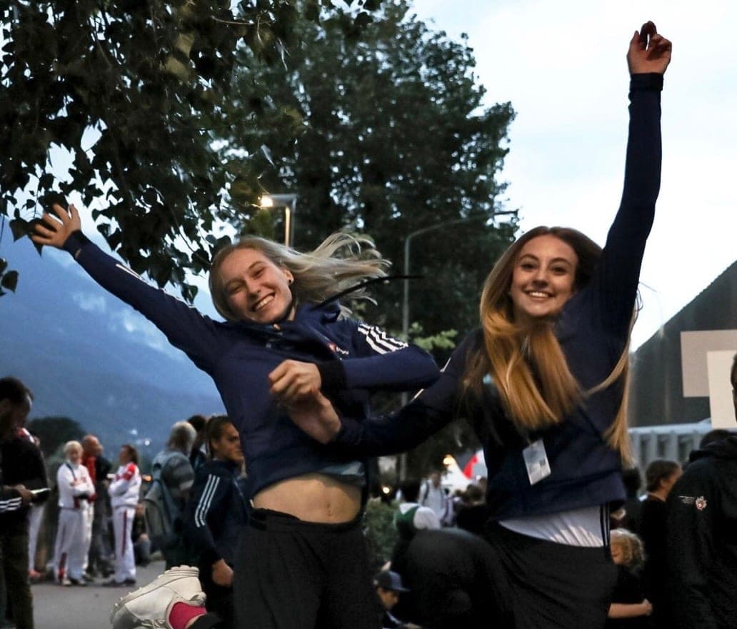 Urška and a friend jumping for joy at a climbing event