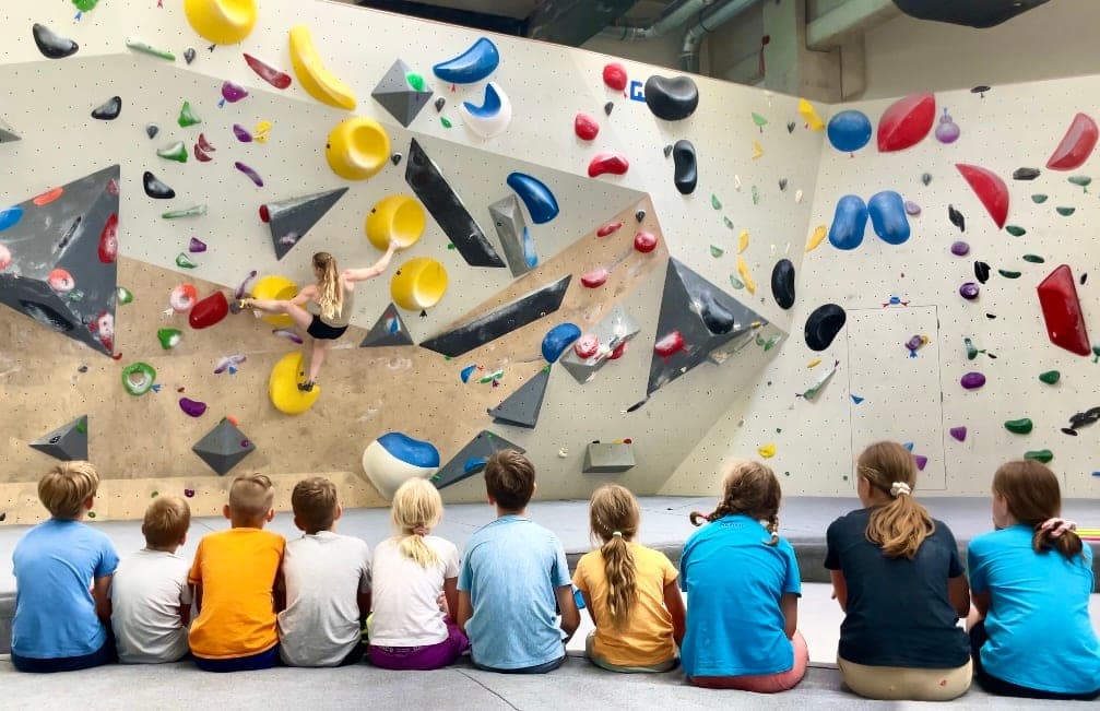 A row of young climbers watching the wall