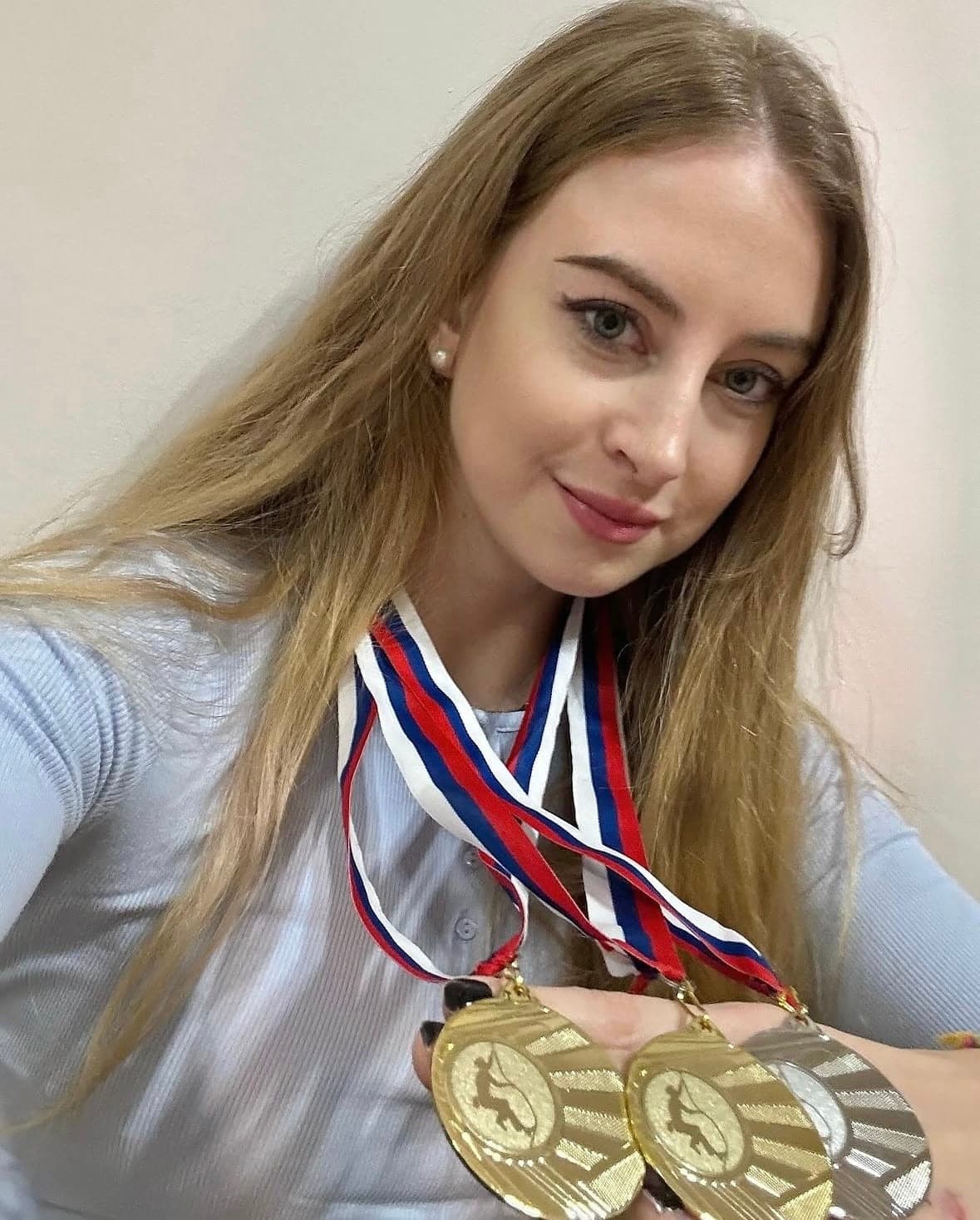 Urška smiling with three gold medals