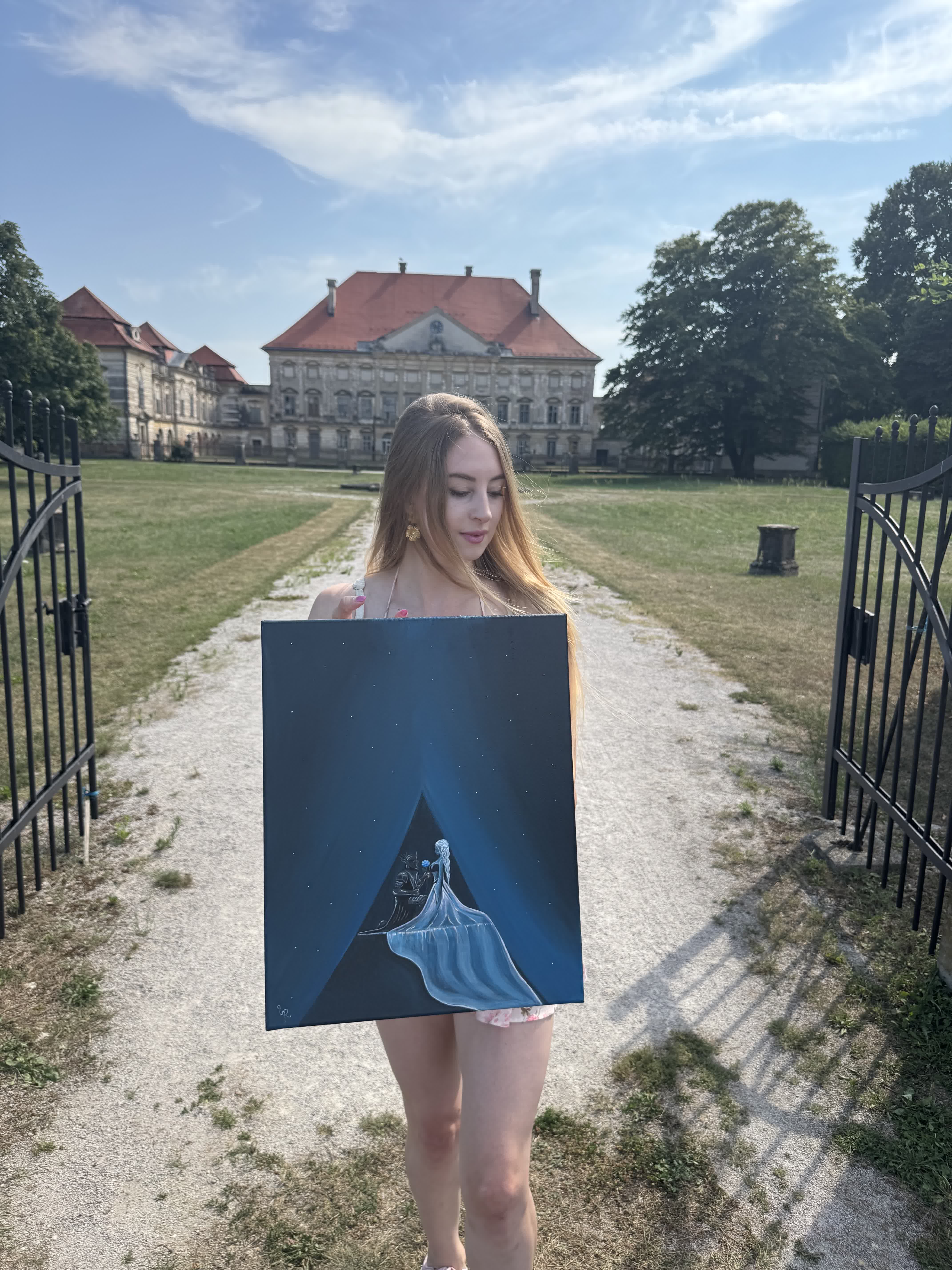 Urška holding the finished 'Eternal Love' canvas at the castle gates