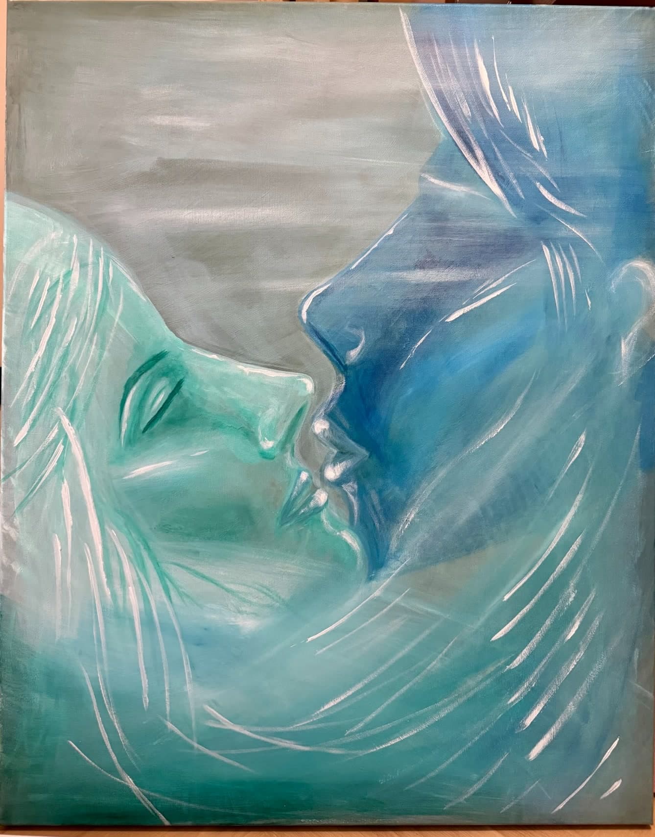 Photograph of an original painting by Urška depicting two faces in profile, rendered in teal and blue tones, close together as if about to kiss.